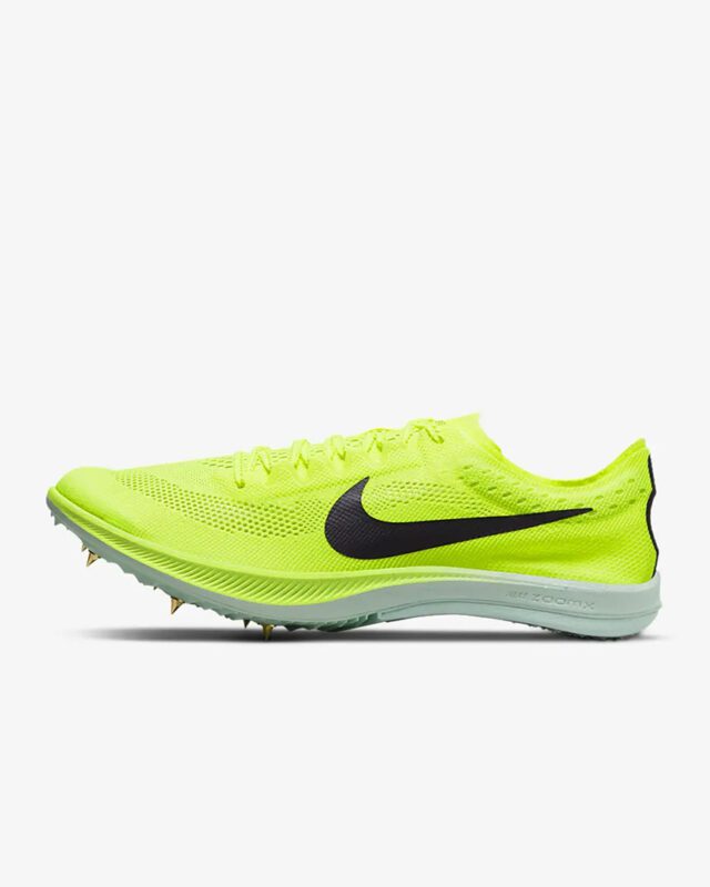 A pair of neon yellow shoes with spikes on them.