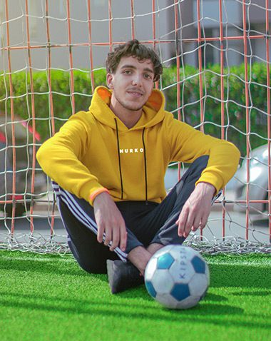 A man sitting on the ground with a soccer ball.