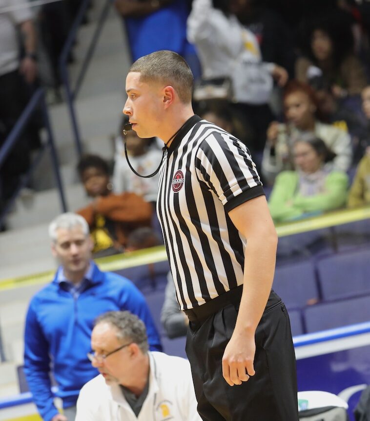 A referee is standing in front of the crowd.