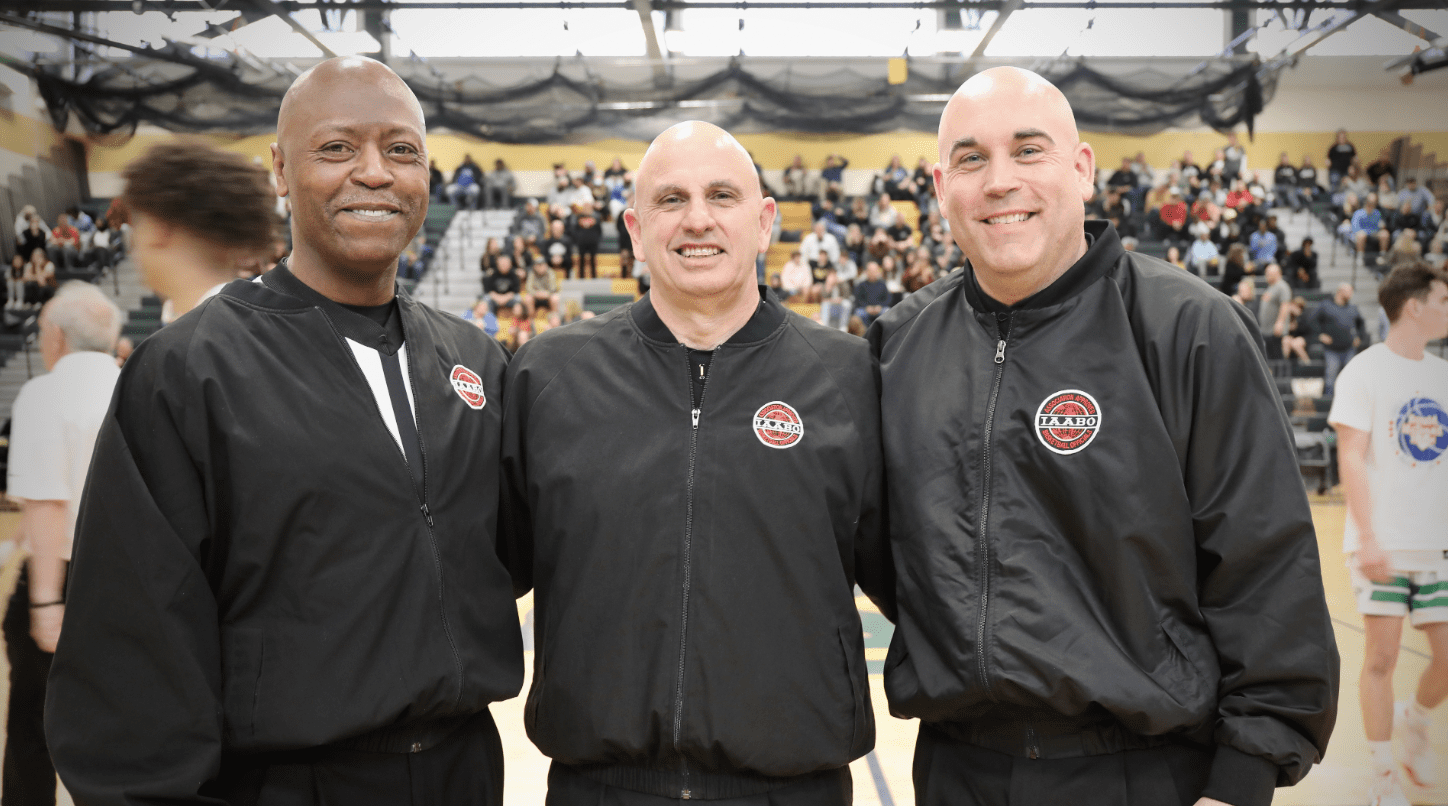 Three men in black jackets standing next to each other.